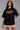 Black POPCASE oversized unisex tshirt with Conquer Yourself in layered red gothic and grey shadow text on front, styled with beige bubble shorts