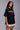 Black POPCASE oversized unisex tshirt with Conquer Yourself in layered red gothic and grey shadow text on front, styled with beige bubble shorts