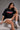 Black POPCASE oversized unisex tshirt with Conquer Yourself in layered red gothic and grey shadow text on front, styled with beige bubble shorts