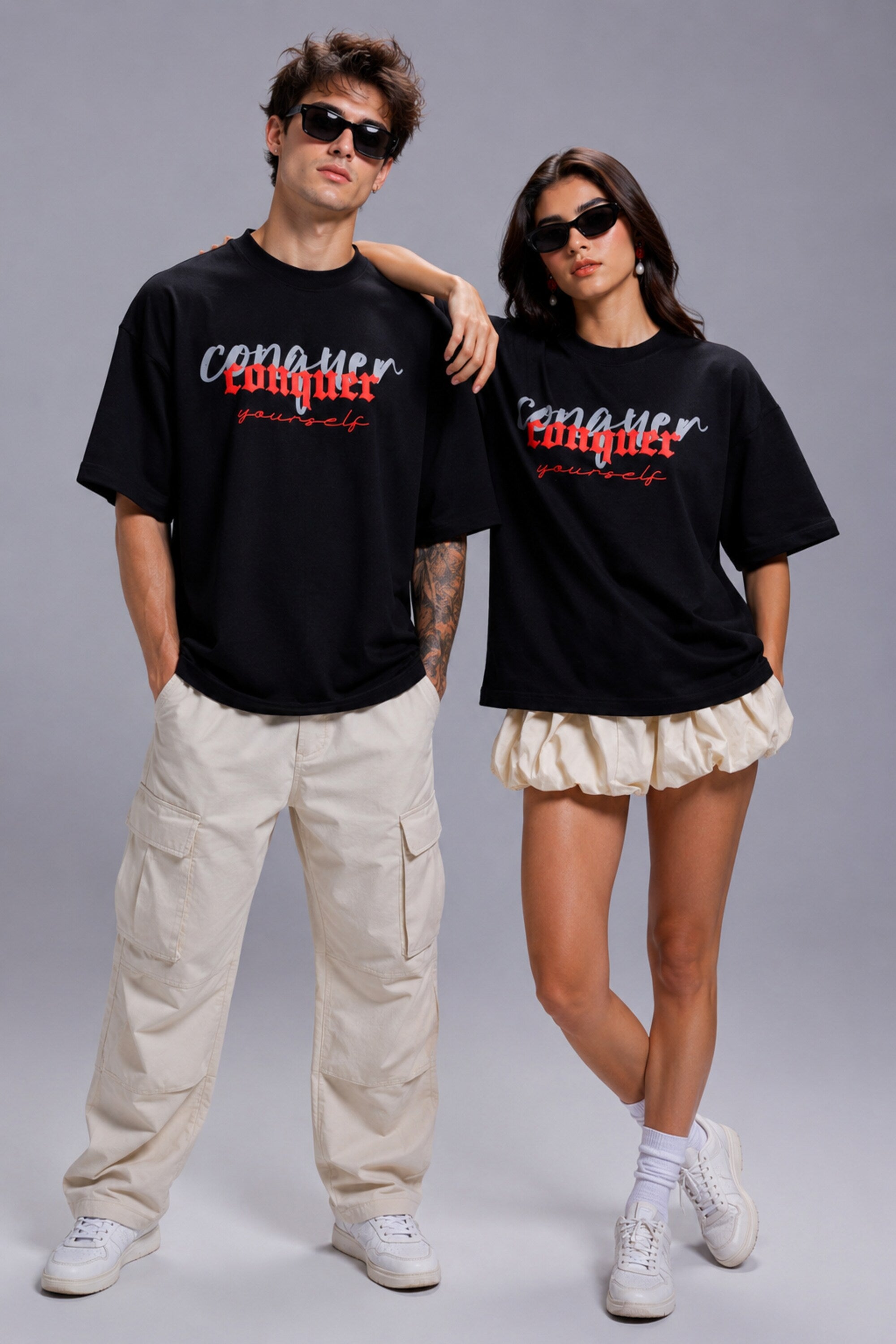 Black POPCASE oversized unisex tshirt with Conquer Yourself in layered red gothic and grey shadow text on front, styled with beige bubble shorts