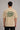 Back view of a man wearing a beige RARE INSIGHT oversized t-shirt with a green "Sorry But I Don't Care" graphic and star accents.