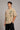 Back view of a man wearing a beige RARE INSIGHT oversized t-shirt with a green "Sorry But I Don't Care" graphic and star accents.