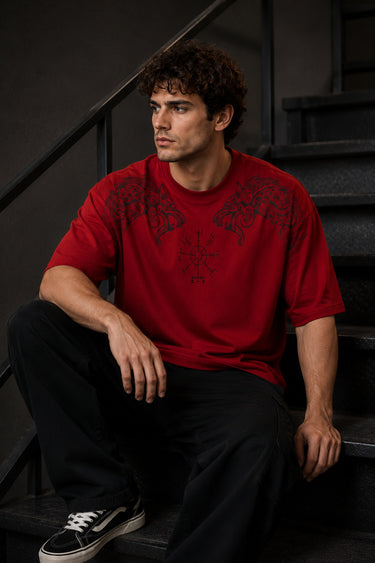 Red Nordic Heritage oversized t-shirt with black Viking-inspired graphic print on the front and back. Close-up shows DTF print quality and fabric texture.