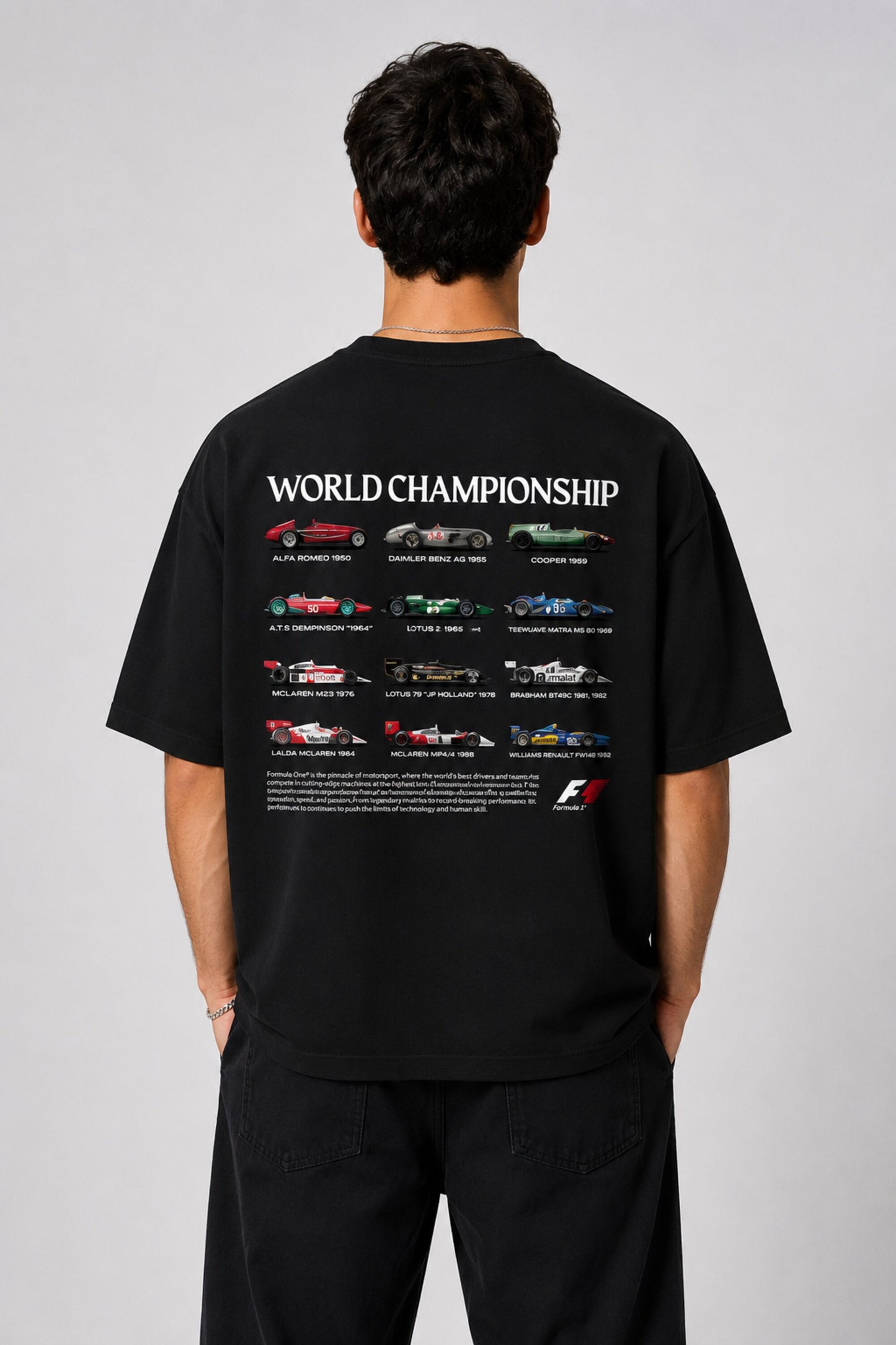 Model wearing a black oversized t-shirt with a small, embroidered Formula 1® logo in white, red, and gray on the chest. Casual streetwear style. - black