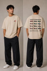 Model wearing a black oversized t-shirt with a small, embroidered Formula 1® logo in white, red, and gray on the chest. Casual streetwear style. - beige