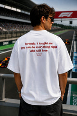 Person wearing a white t-shirt with a quote at a Formula 1 track