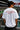 Person wearing a white t-shirt with a quote at a Formula 1 track
