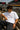 Man wearing sunglasses and a white t-shirt with 'POPCASE' logo at a Formula 1 event.