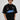 Model wearing a black Fast Feels Forever oversized t-shirt with graphic prints, sitting on a leather couch. - black