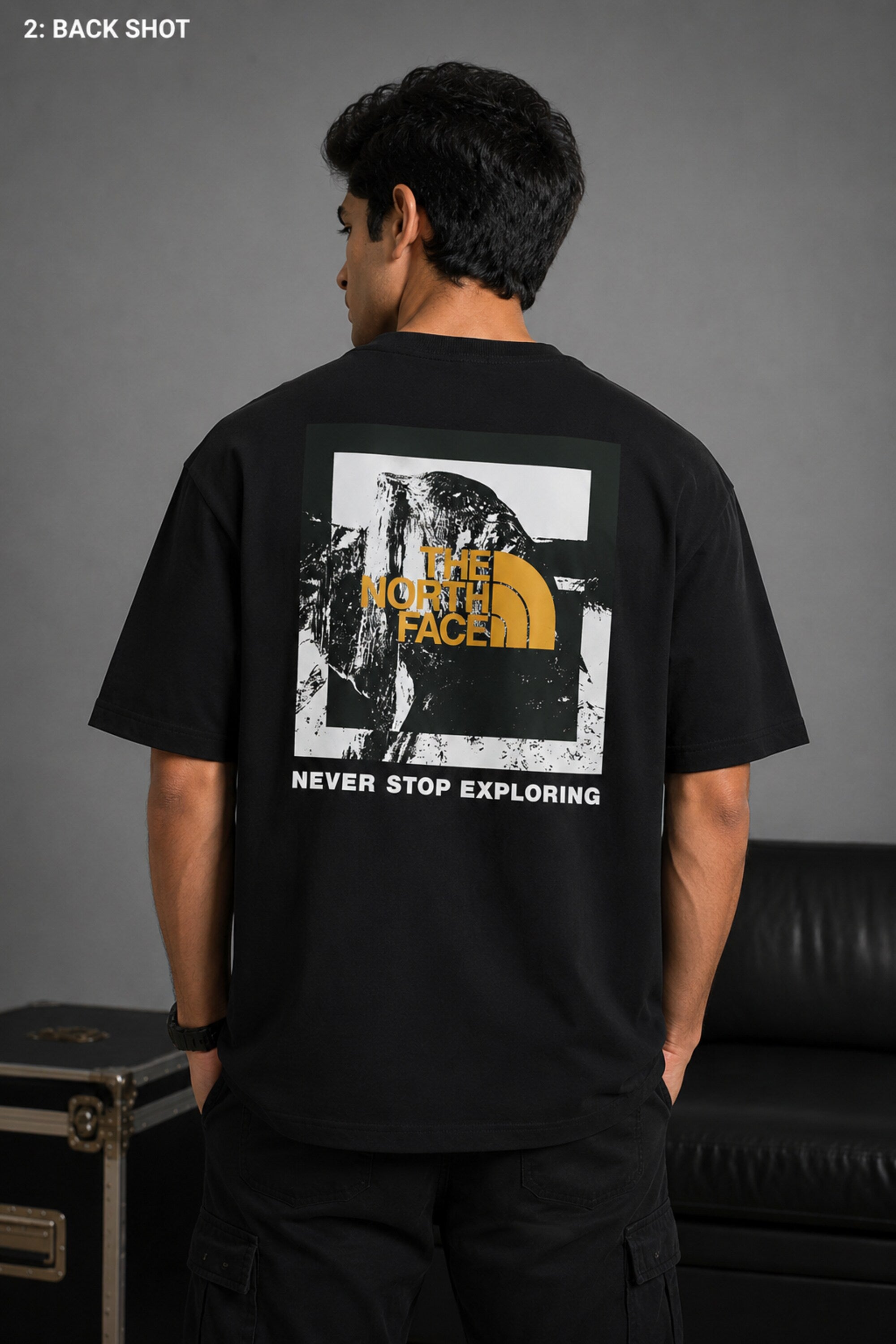 Man wearing FROM THE NORTH oversized t-shirt in beige with black cargo pants and white sneakers. Features The North Face logo and graphic on front and back.