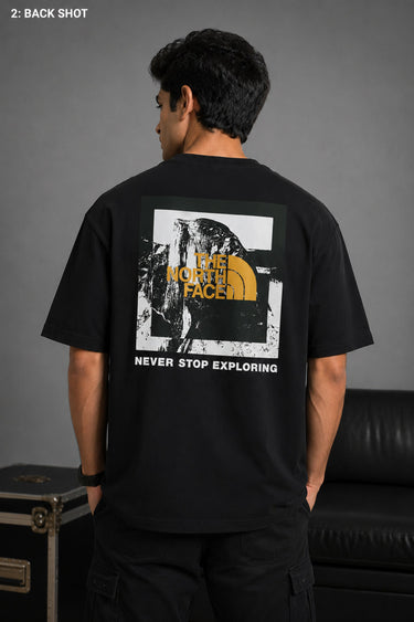 Man wearing FROM THE NORTH oversized t-shirt in beige with black cargo pants and white sneakers. Features The North Face logo and graphic on front and back.