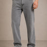 Person wearing gray jeans and white sneakers on a beige background