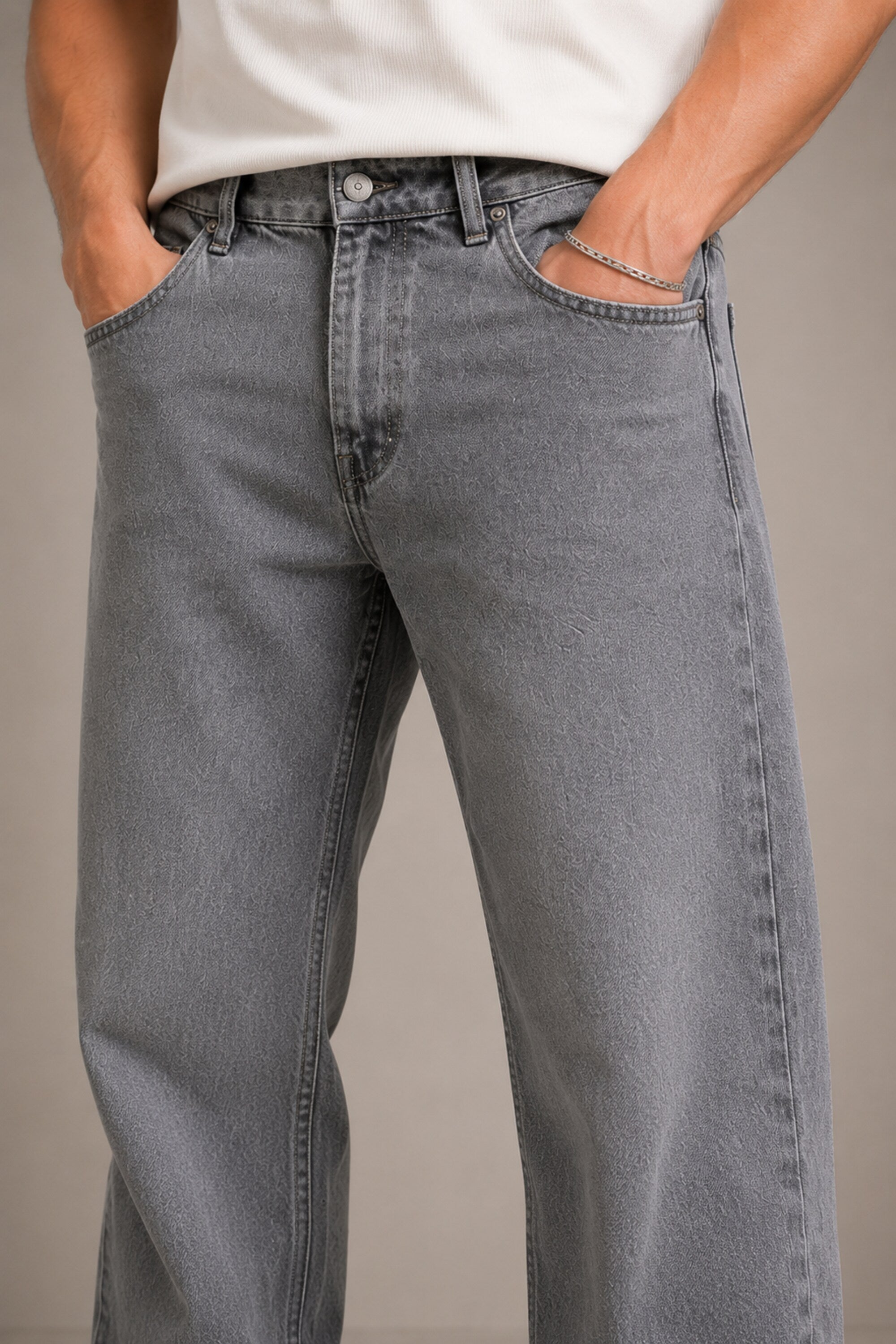 Person wearing gray jeans with a plain background