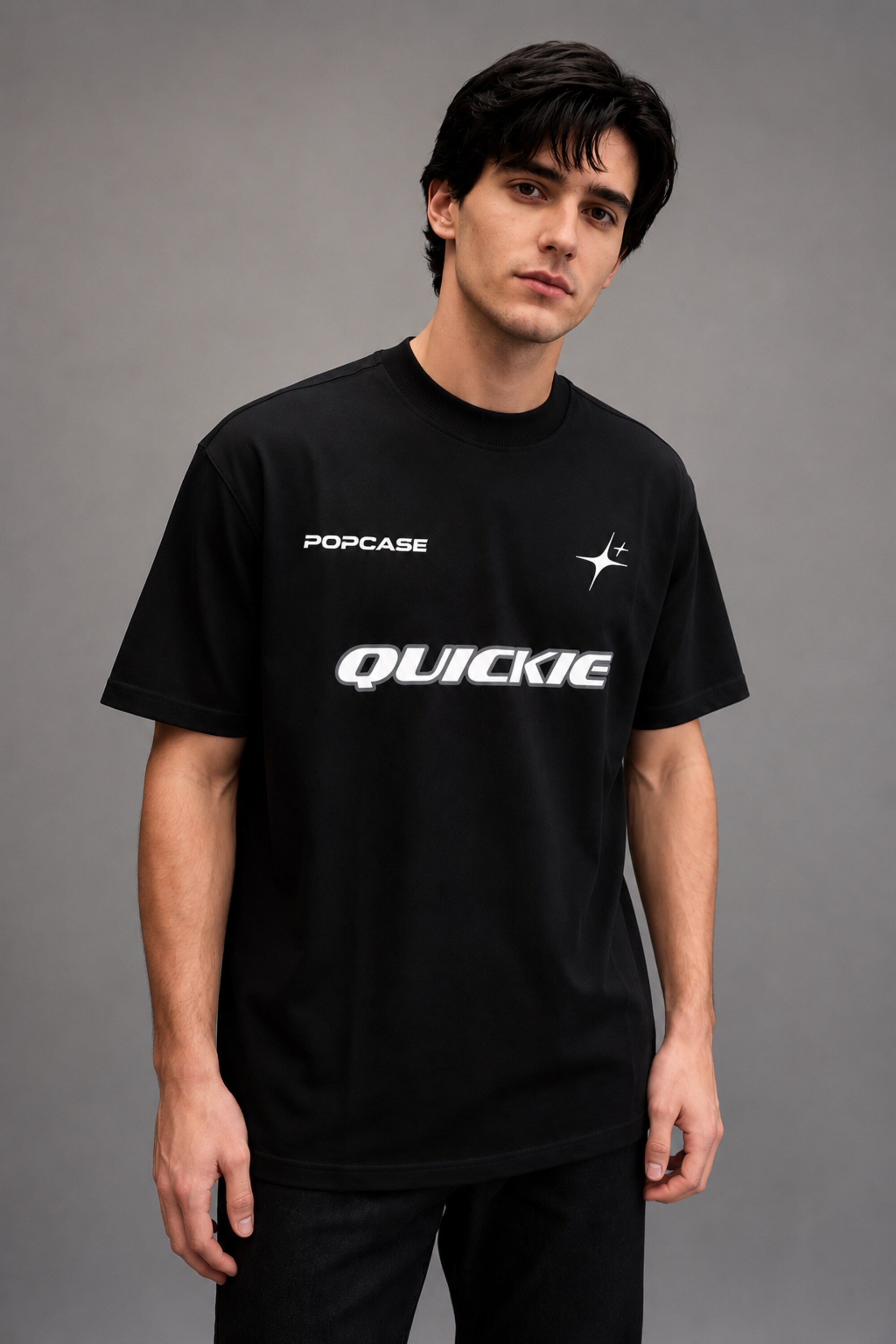 Black QUICKE oversized t-shirt featuring bold white graphic print on the chest and back. Showcasing premium fabric details and relaxed fit.
