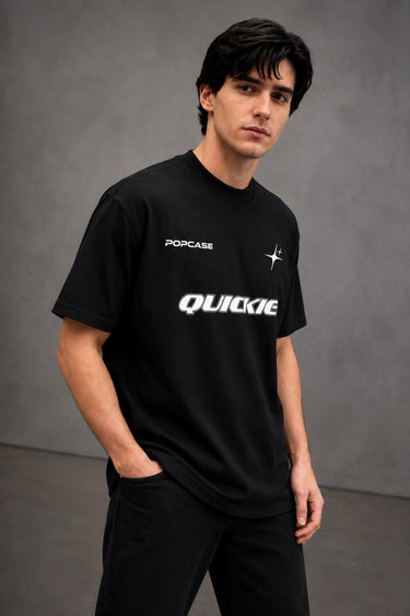 Black QUICKE oversized t-shirt featuring bold white graphic print on the chest and back. Showcasing premium fabric details and relaxed fit.