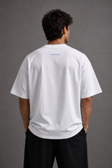 White oversized t-shirt featuring a striking black and blue graphic of Hanuman Dada, with a large blue halo. Designed for a relaxed, streetwear fit.