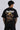 Red oversized t-shirt with 'PROJECTOR HANUMANJI' graphic design of a warrior monkey god and 'POPCASE' logo, worn by a man.