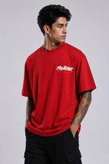 Red oversized t-shirt with 'PROJECTOR HANUMANJI' graphic design of a warrior monkey god and 'POPCASE' logo, worn by a man.