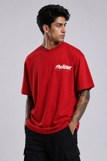 Red oversized t-shirt with 'PROJECTOR HANUMANJI' graphic design of a warrior monkey god and 'POPCASE' logo, worn by a man.