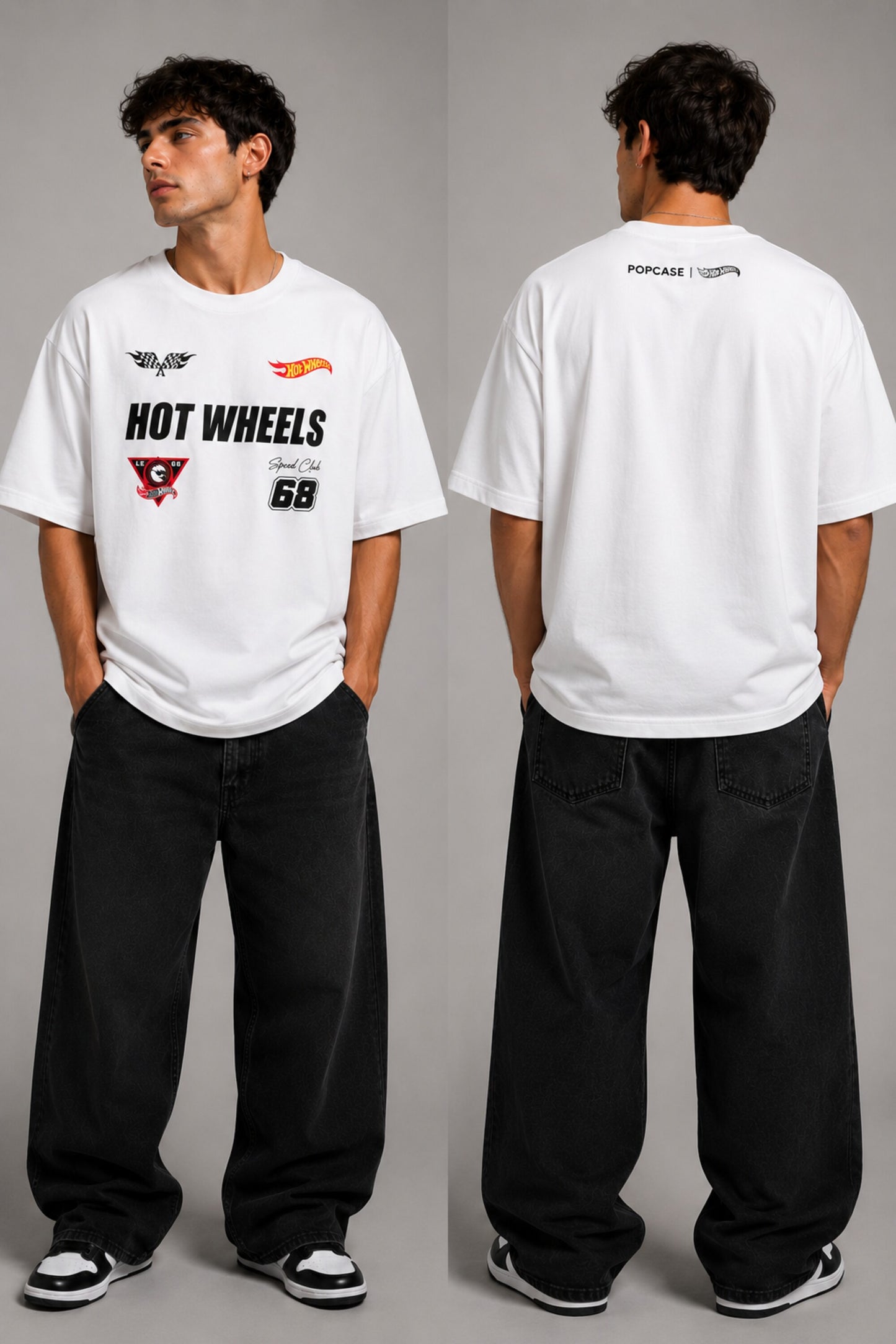 Man wearing a black STAR BOY oversized t-shirt with "Hot Wheels" graphics, sitting on a black couch. Streetwear fashion. - white