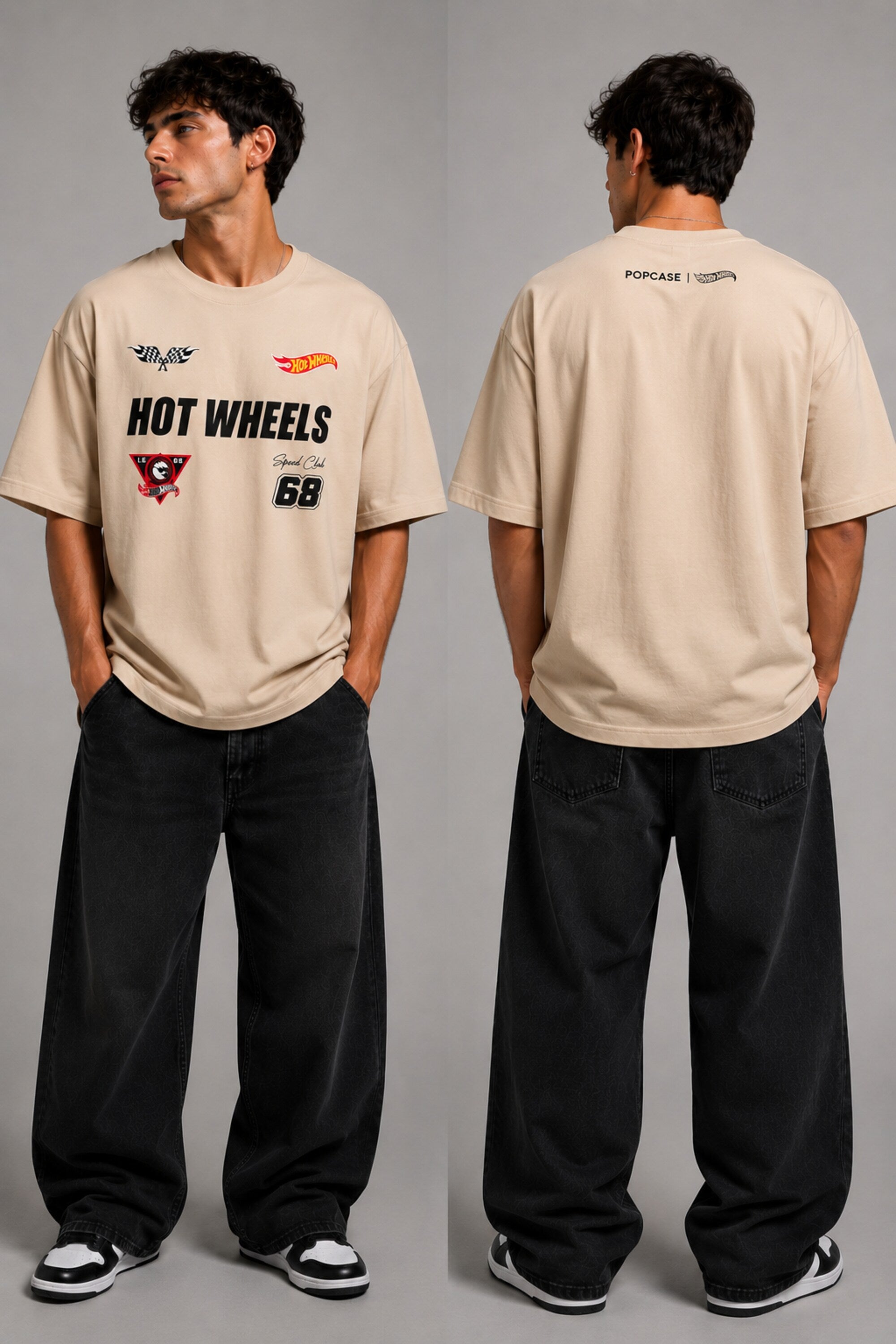 Man wearing a black STAR BOY oversized t-shirt with "Hot Wheels" graphics, sitting on a black couch. Streetwear fashion. - beige