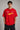 Couple wearing matching red oversized Hot Wheels t-shirts and black bottoms, standing on stairs. Feature iconic Hot Wheels logo. - red