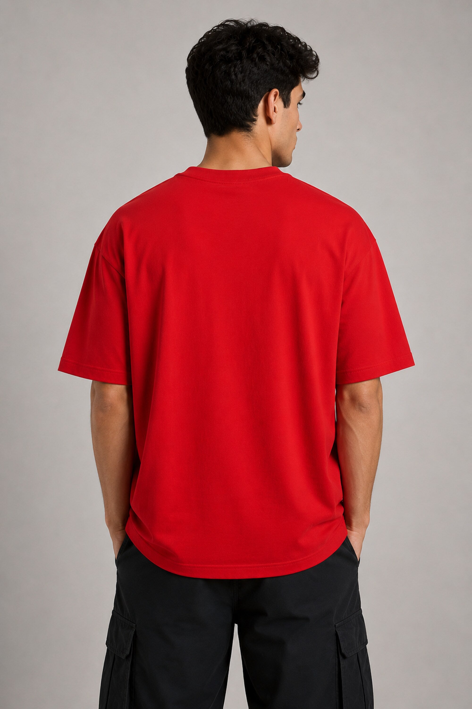 Couple wearing matching red oversized Hot Wheels t-shirts and black bottoms, standing on stairs. Feature iconic Hot Wheels logo.