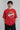Model wearing a black oversized t-shirt with a vintage Hot Wheels graphic and flames. The tee has a relaxed fit and is paired with black pants. - red