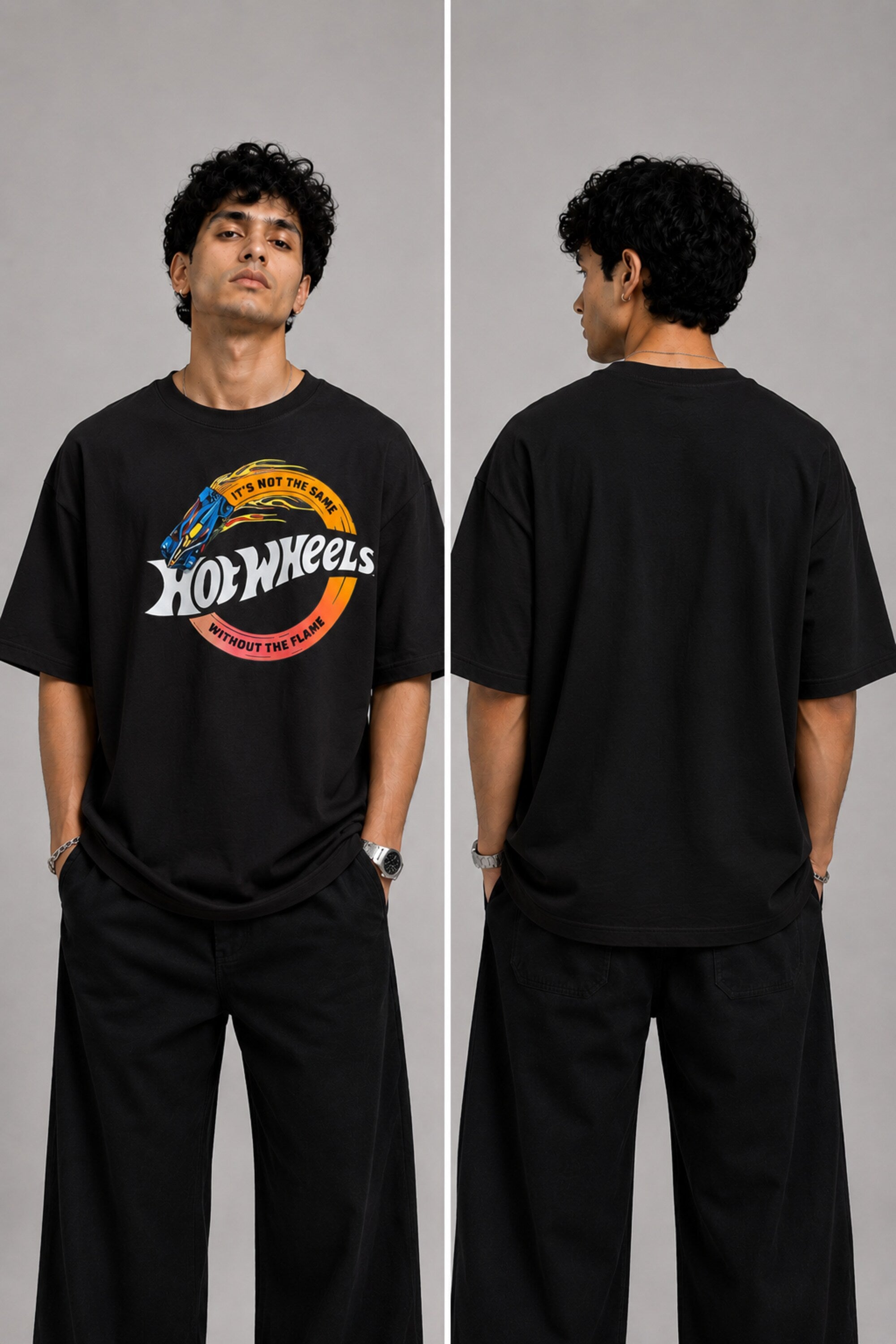 Model wearing a black oversized t-shirt with a vintage Hot Wheels graphic and flames. The tee has a relaxed fit and is paired with black pants.