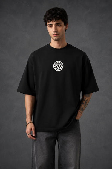 Couple wearing black Iron Man Jarvish oversized t-shirts. Man's back shows "IRON MAN" logo. Woman's front shows Iron Man arc reactor logo. Dark grey background.