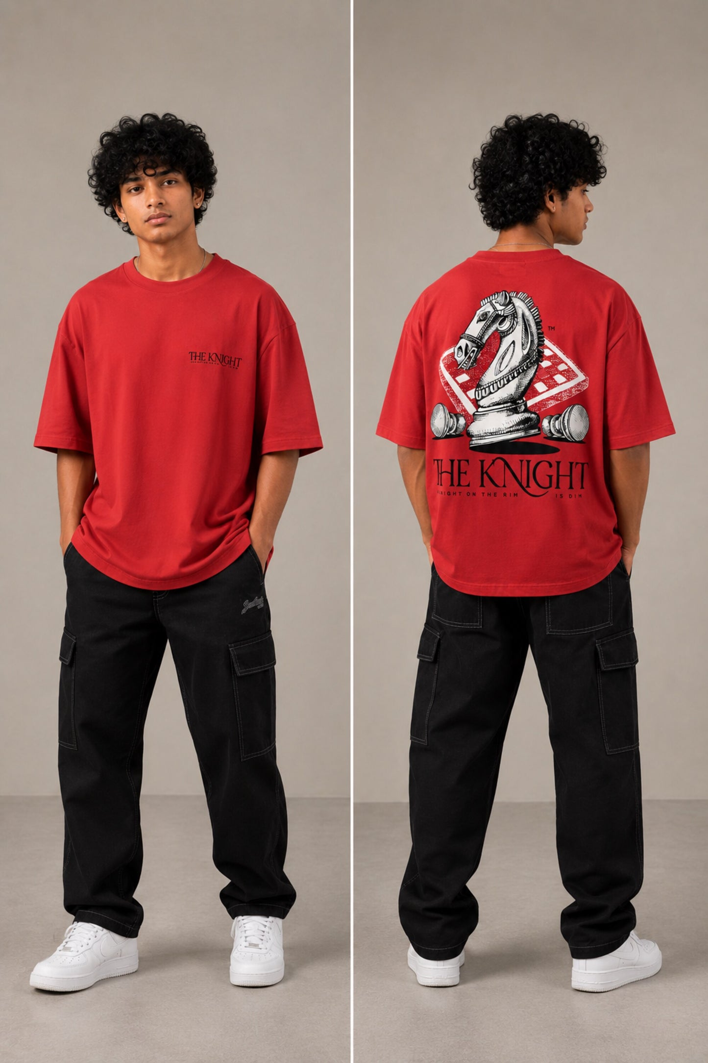 Man wearing a white 'THE KNIGHT' oversized t-shirt and black pants, sitting on concrete stairs. Features short curly hair and white sneakers. - red