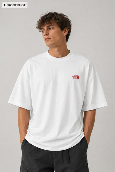 Model wearing a white POP-FROM-THE-NORTH oversized t-shirt with a small red logo on the chest, styled with black cargo pants, showcasing a relaxed streetwear fit.