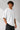 Model wearing a white POP-FROM-THE-NORTH oversized t-shirt with a small red logo on the chest, styled with black cargo pants, showcasing a relaxed streetwear fit.