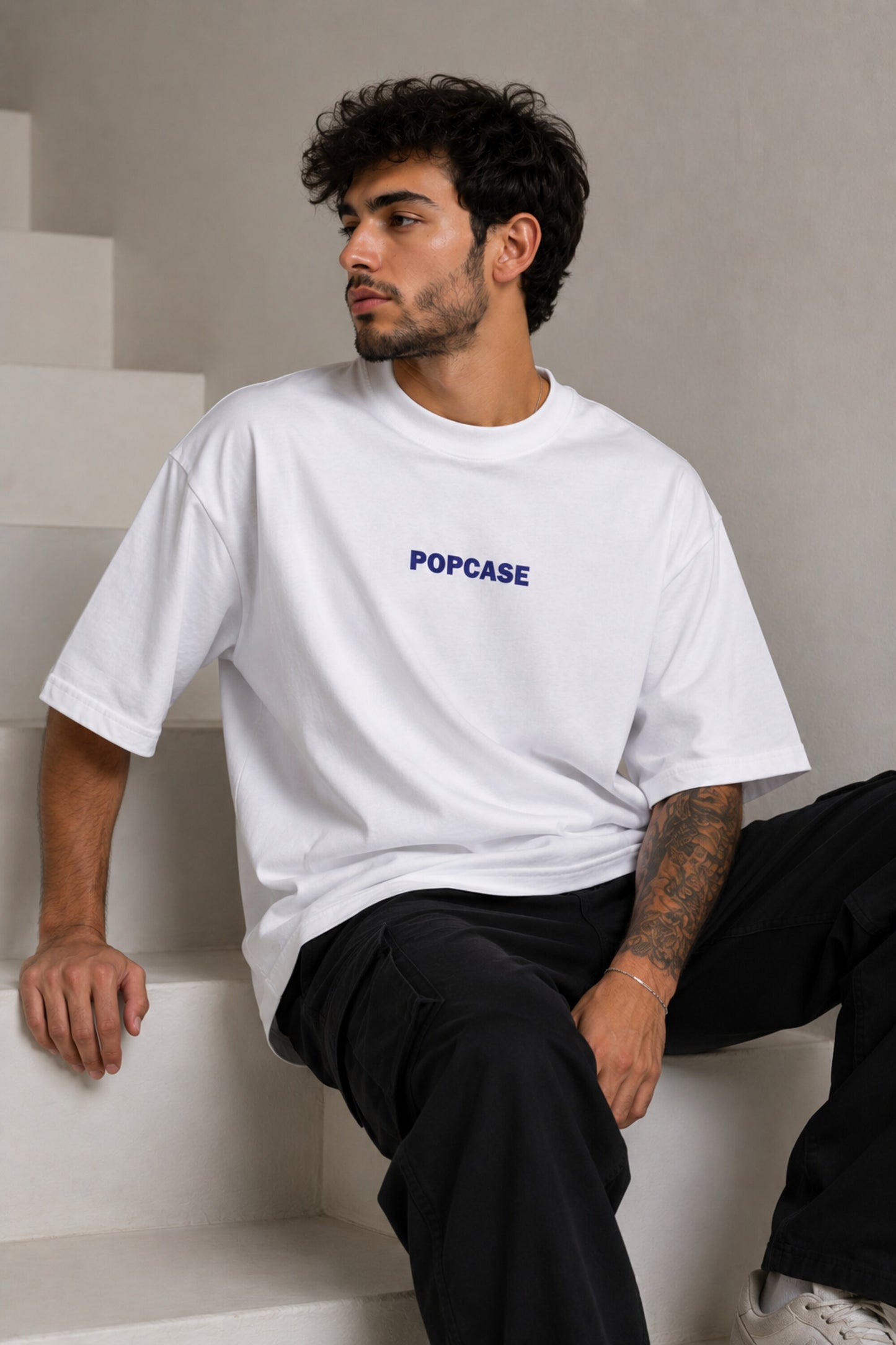 White POPCASE oversized tshirt with i'm not cristiano ronaldo but i also hate losing quote in navy on back, POPCASE Since 2022 tagline