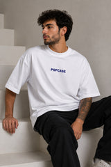White POPCASE oversized tshirt with i'm not cristiano ronaldo but i also hate losing quote in navy on back, POPCASE Since 2022 tagline