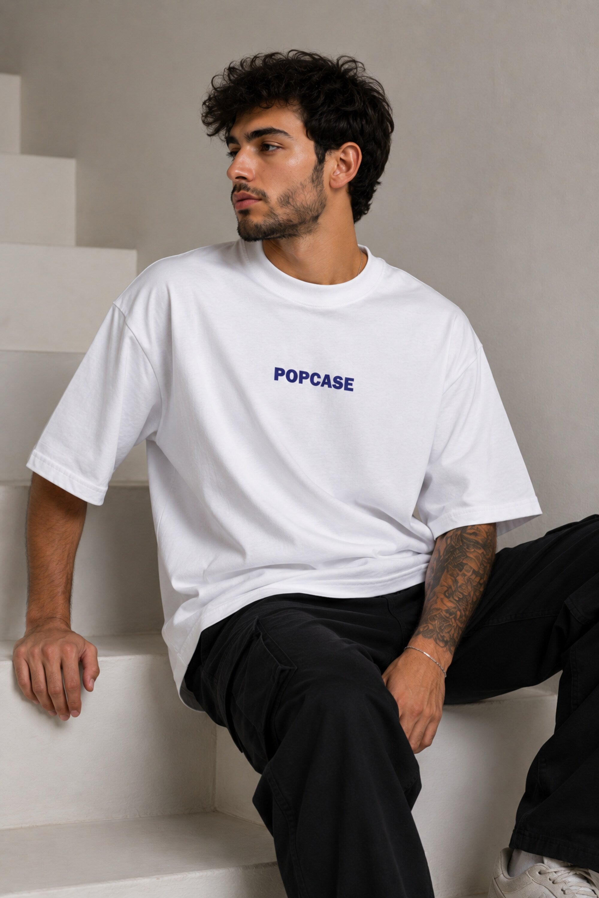 White POPCASE oversized tshirt with i'm not cristiano ronaldo but i also hate losing quote in navy on back, POPCASE Since 2022 tagline