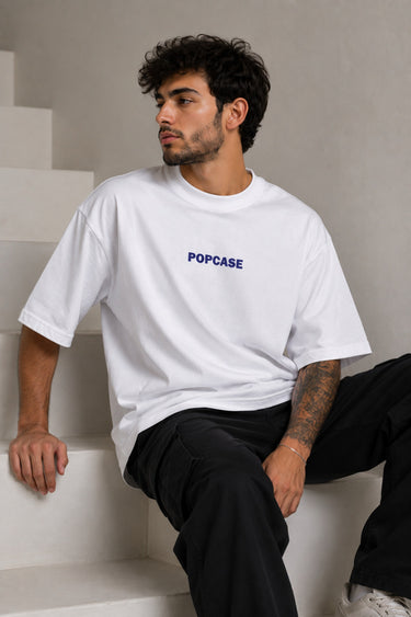 White POPCASE oversized tshirt with i'm not cristiano ronaldo but i also hate losing quote in navy on back, POPCASE Since 2022 tagline