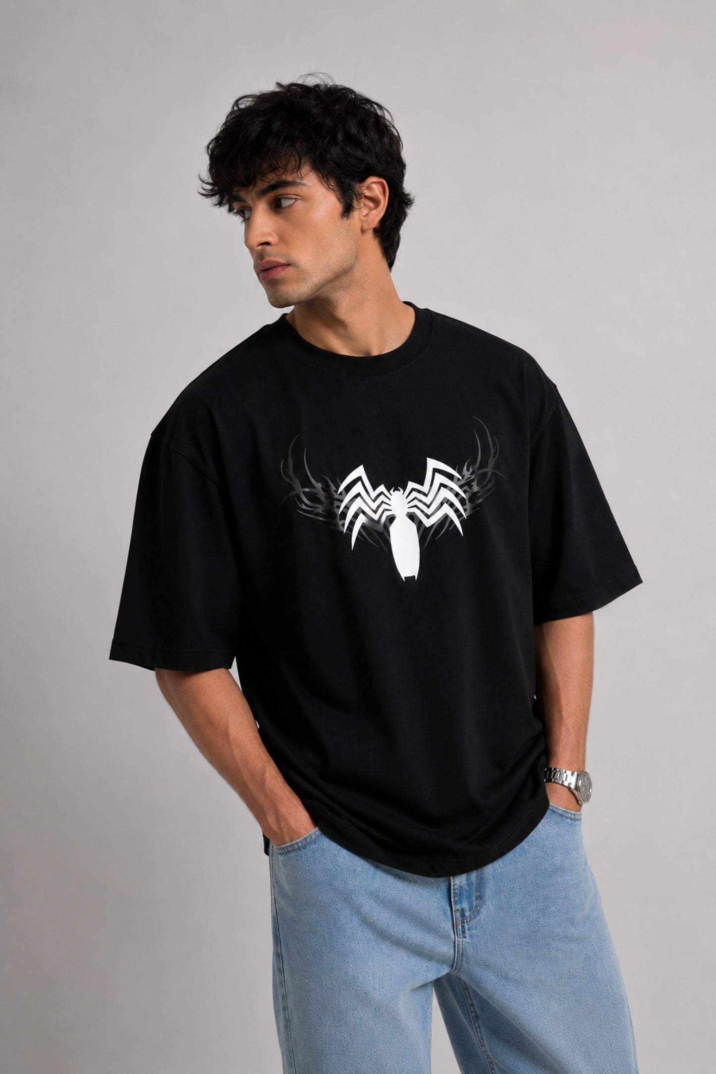 Person wearing a black t-shirt with a white logo on a plain background