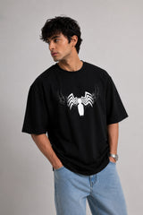 Person wearing a black t-shirt with a white logo on a plain background