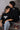 Two people sitting on steps with black shirts featuring spider-like designs.