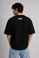 Person wearing a black t-shirt with 'Venom' logo on the back against a gray background