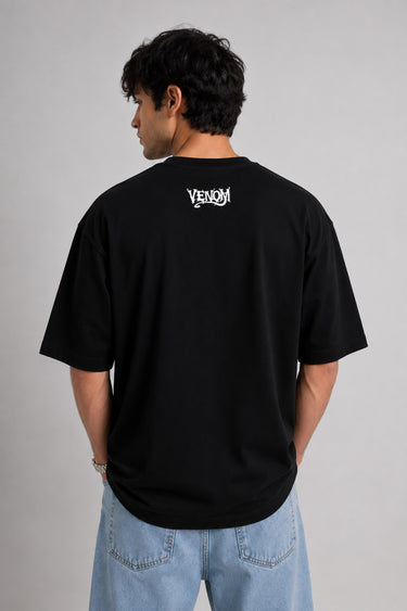 Person wearing a black t-shirt with 'Venom' logo on the back against a gray background