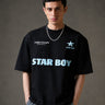 Black STAR BOY oversized t-shirt with a light blue raised graphic of a star and text. Detailed fabric texture shown. - black