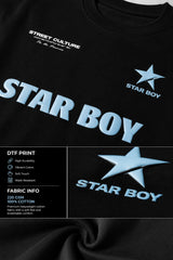 Black STAR BOY oversized t-shirt with a light blue raised graphic of a star and text. Detailed fabric texture shown.
