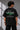 Beige oversized t-shirt featuring a vibrant green Porsche 911 RS RAWK graphic and 'Drifting Club' text. Mockup highlighting premium cotton fabric and stitching details.