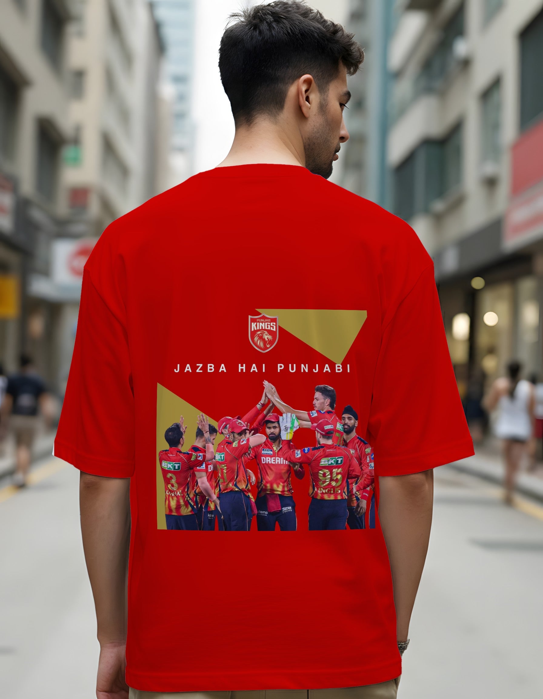 Person wearing a red t-shirt with a graphic design on the back in an urban setting