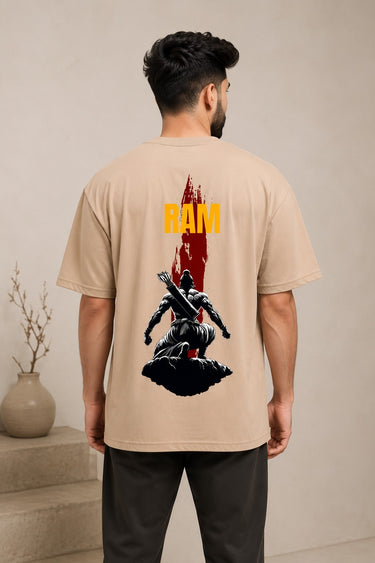 Model wearing a beige RAM oversized t-shirt with a red graphic print on the chest, paired with dark trousers and white sneakers. Showcases streetwear style and premium comfort. - beige