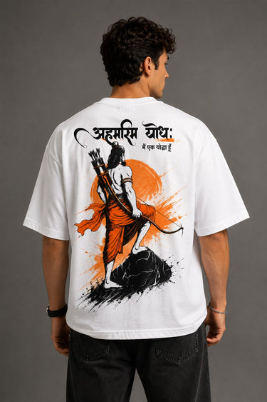 Man wearing a white RAM YODHA oversized t-shirt with 'Ram' graphic on front and Ram Yoddha artwork on back, seated on wooden steps.
