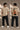 Man wearing a white RAM YODHA oversized t-shirt with 'Ram' graphic on front and Ram Yoddha artwork on back, seated on wooden steps. - beige