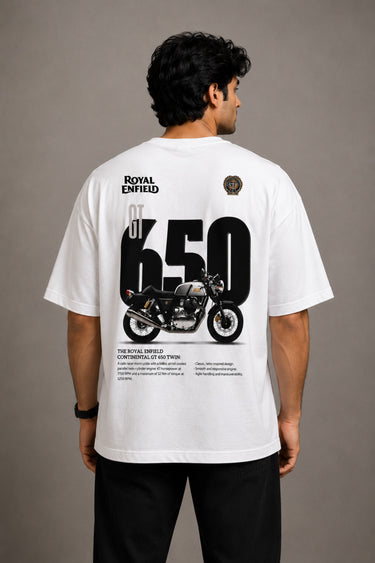 Man wearing a white oversized Royal Enfield t-shirt with a classic cannon graphic. Features a relaxed fit and modern streetwear aesthetic.